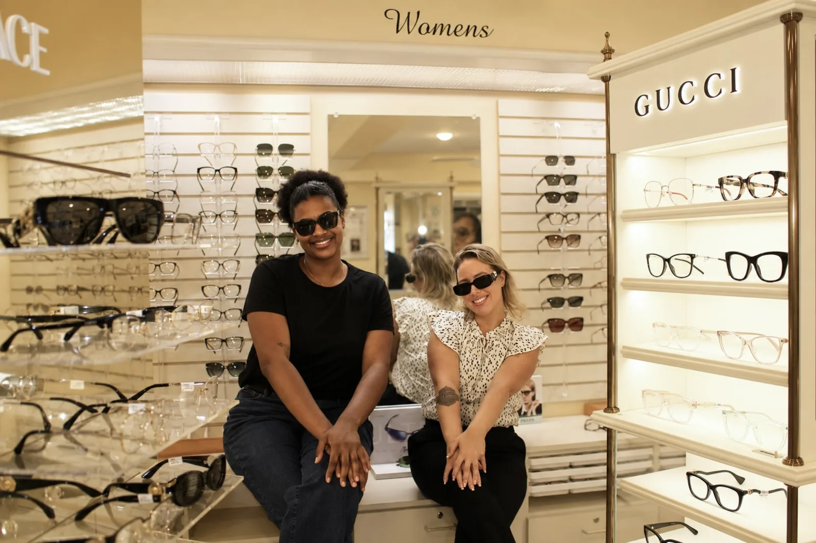 Two people trying on sunglasses in the North Providence optical.